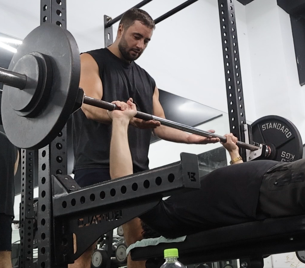 Nico Fligge spotting a client during a bench press at his gym in Da Nang.